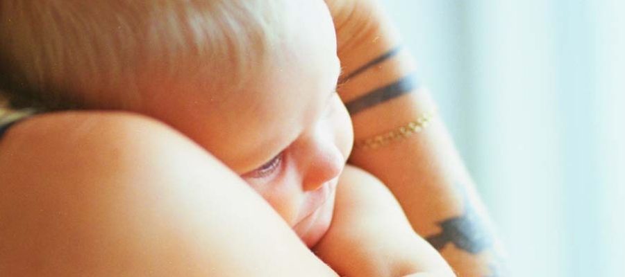 Mor holder sit barn tæt ind til brystet.